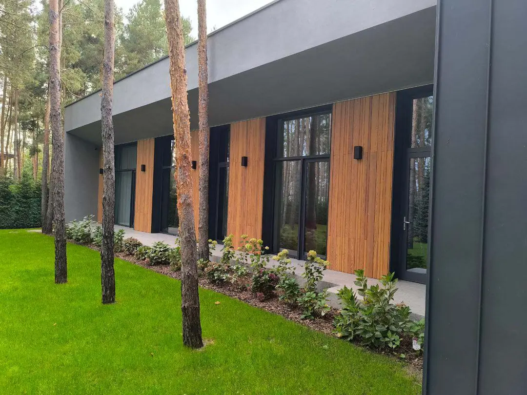 Riviera Passive House garden facade framed by pine trees