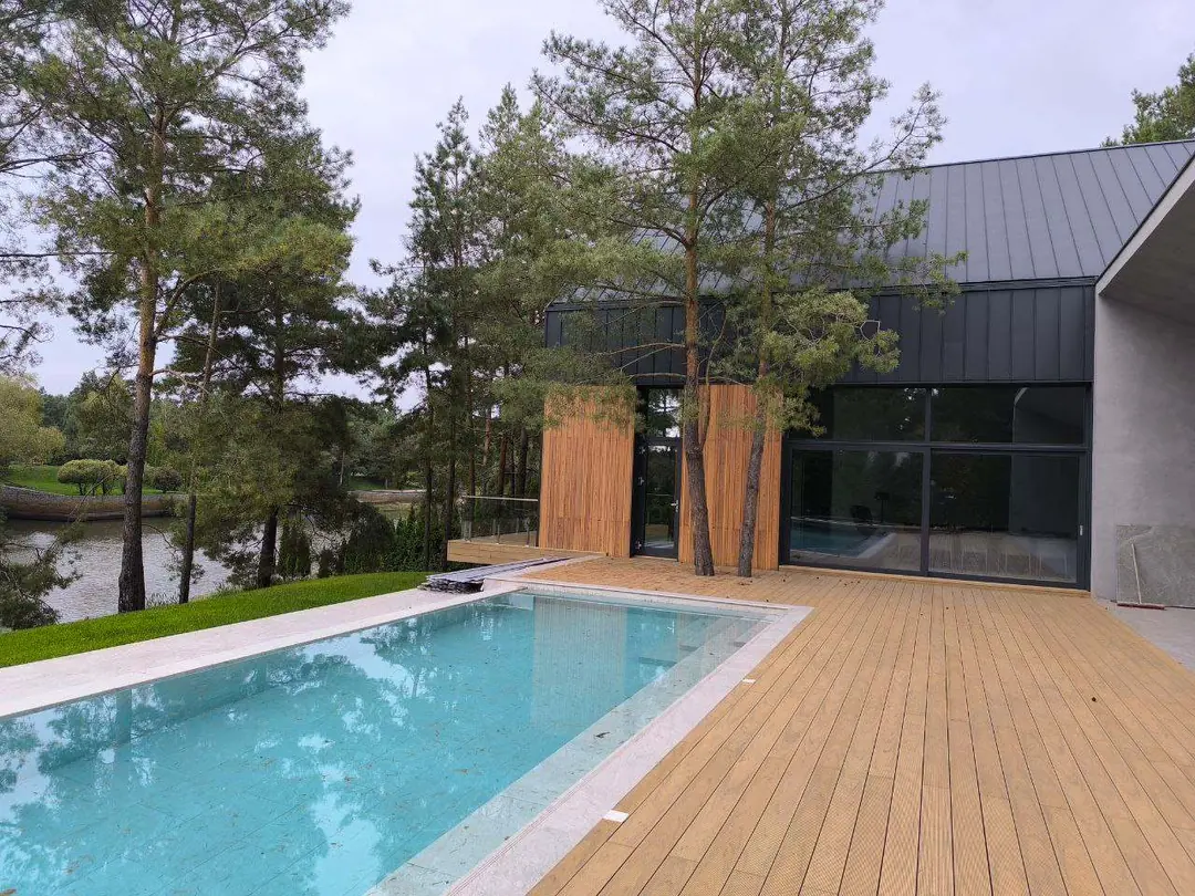 Riviera Passive House pool terrace beside a river and pine trees